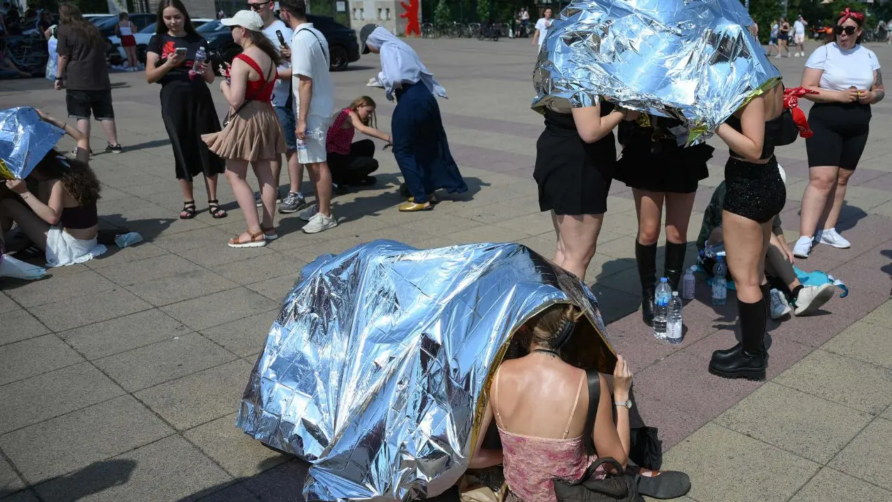 People us emergency blankets to protect them from the heat in Berlin. PIC/AFP